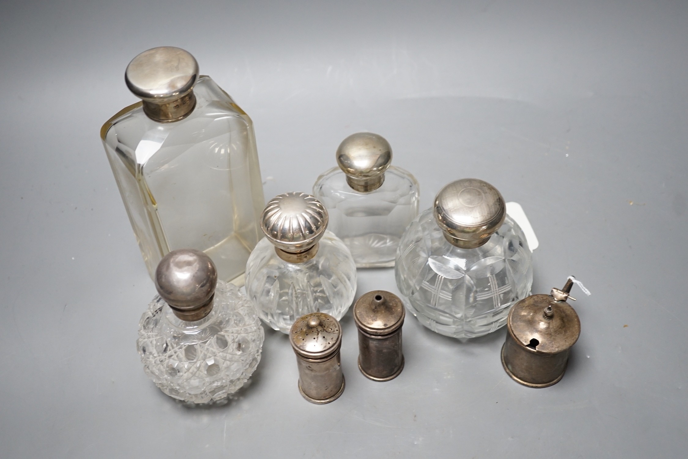 Three silver mounted glass scent bottles, a large silver mounted glass toilet bottle and three silver condiments.